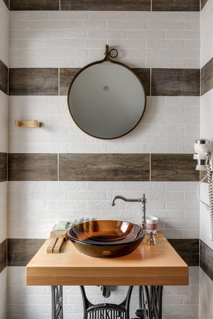 pexels-photo-7745938 Stylish bathroom interior featuring a modern vessel sink, round mirror, and unique design elements.